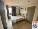 Modern bedroom interior with a comfortable double bed, window with curtains, air conditioning unit, and wooden flooring