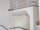 White wooden staircase with handrails in a modern home