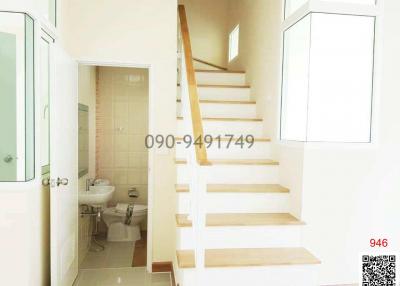 Bright interior view of a staircase ascending beside a bathroom