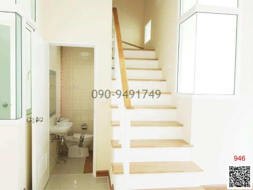 Bright interior view of a staircase ascending beside a bathroom