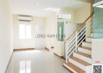 Spacious and well-lit empty room with staircase and air conditioner