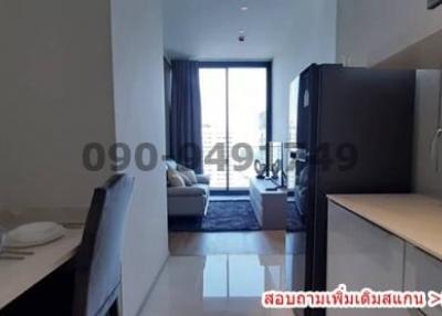 Modern apartment interior view showing kitchen leading to living room