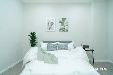 Modern bedroom interior with white bedding and decorative wall art