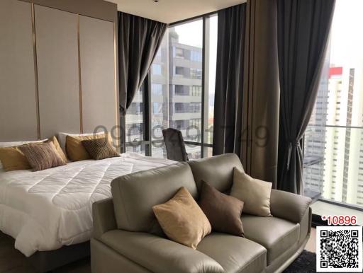 Modern bedroom with expansive windows and city view, featuring a king-size bed and plush seating area