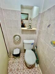 Compact bathroom with wall-mounted mirror and tiled walls