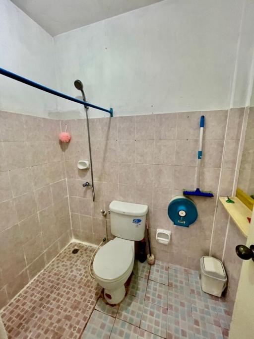 Small tiled bathroom with toilet and accessories