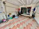 Spacious covered patio area with tiled flooring and various household items