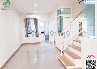 Bright and spacious hallway with staircase and tile flooring