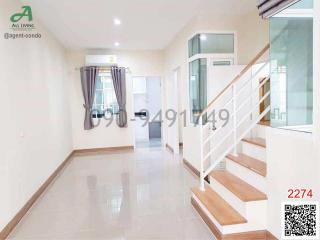 Bright and spacious hallway with staircase and tile flooring