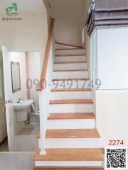 Wooden staircase with white balusters adjacent to a bathroom entrance in a residential home