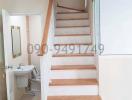 Wooden staircase with white balusters adjacent to a bathroom entrance in a residential home