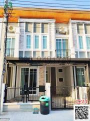 Modern two-story townhouse exterior with balcony and front yard fence