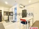 Modern kitchen with white fittings, bar dining area, and glossy tiled floor