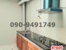 Compact modern kitchen with stainless steel sink and wooden cabinets