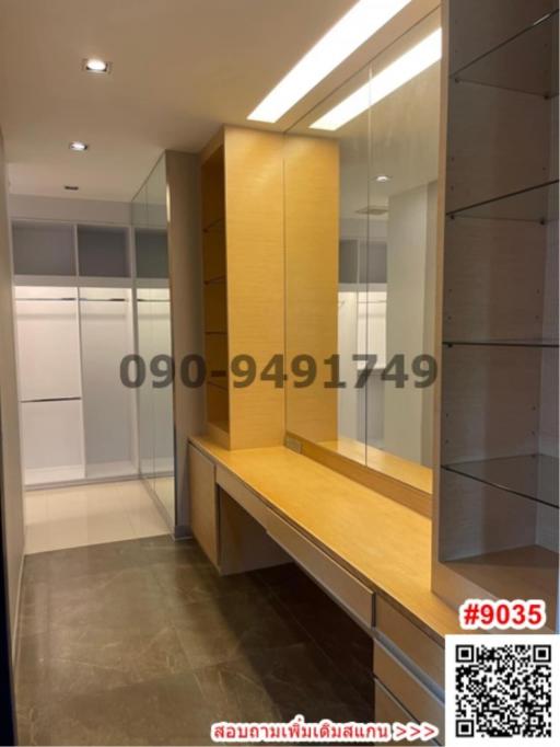 Modern hallway with built-in wooden desk and shelves, featuring a glass partition and ample lighting