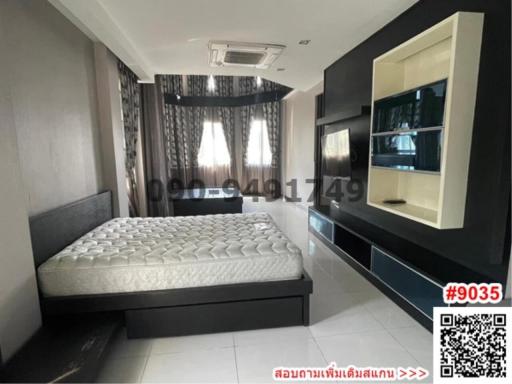Spacious modern bedroom with large bed and entertainment unit