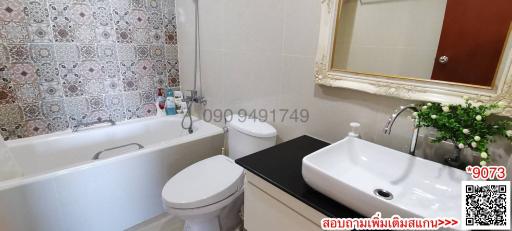 Spacious bathroom with modern fixtures and decorative tiles