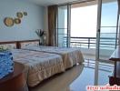 Spacious bedroom with ocean view and balcony access