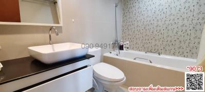 Modern bathroom with white fixtures and patterned wall