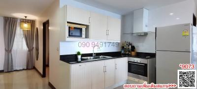 Modern kitchen with integrated appliances and white cabinetry in an apartment