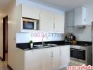 Modern kitchen with integrated appliances and white cabinetry in an apartment