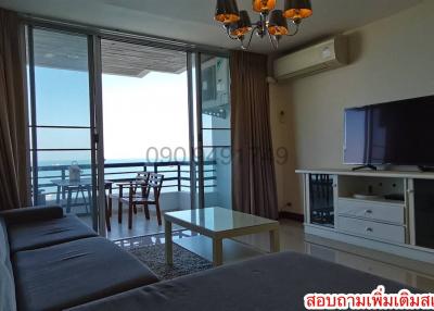 Spacious living room with ocean view, balcony access, and modern furniture