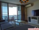 Spacious living room with ocean view, balcony access, and modern furniture