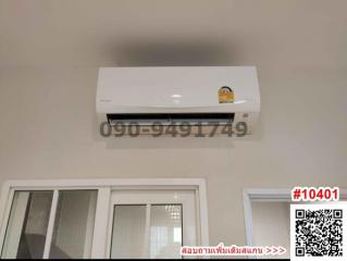 Air conditioner unit on wall above windows