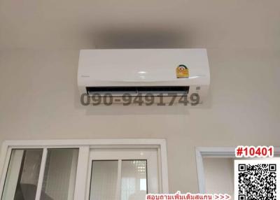 Air conditioner unit on wall above windows