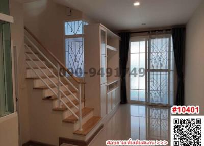 Spacious living room with staircase and ample natural light