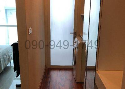 Hallway leading to a bedroom with wooden flooring and built-in wardrobes