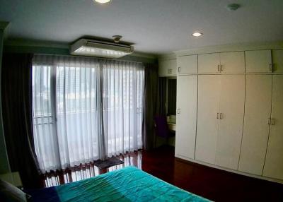 Spacious bedroom with large built-in wardrobe and ample natural light