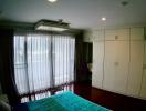 Spacious bedroom with large built-in wardrobe and ample natural light