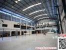 Spacious industrial warehouse interior with high ceiling and office space