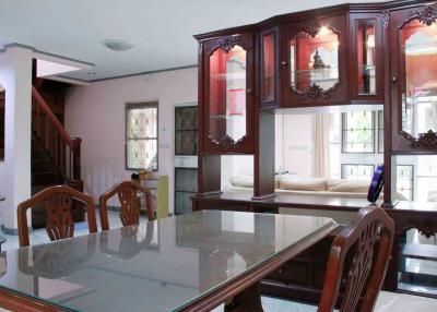 Elegant living room interior with a glass dining table and classic wooden furniture