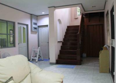 Spacious living area with staircase and multiple entry doors