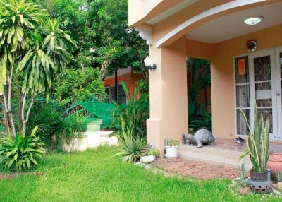 Cozy house exterior with lush garden and welcoming entrance