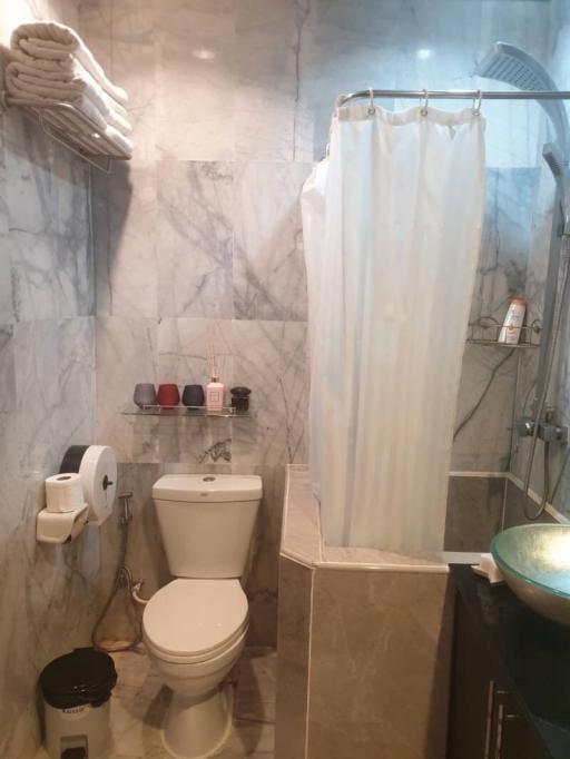 Modern bathroom with marble tiles and shower curtain