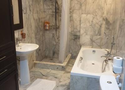 Marble tiled bathroom with bathtub and shower