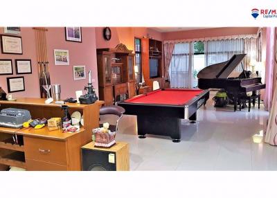 Spacious living room with grand piano and billiards table