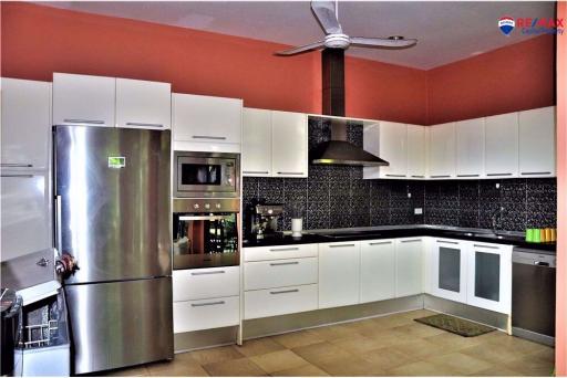 Modern kitchen with red walls, white cabinetry, and stainless steel appliances