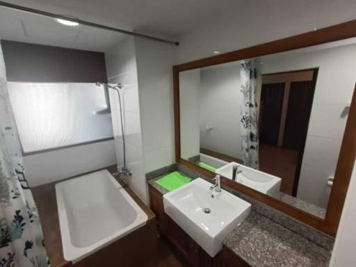 Modern bathroom with bathtub, shower, and large mirror
