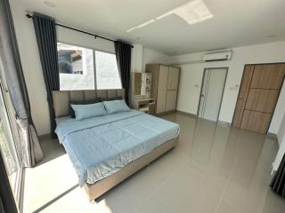 Spacious bedroom with large bed, wardrobe, and modern furnishings