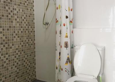 Modern bathroom with patterned tile wall and white fixtures