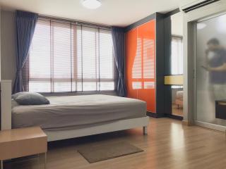 Spacious bedroom with queen-size bed, modern decor, and ample natural light