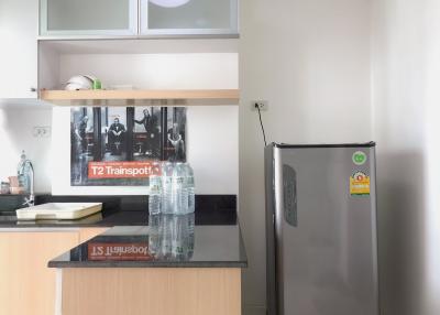 Modern kitchen with stainless steel refrigerator and wooden cabinets