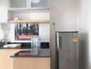 Modern kitchen with stainless steel refrigerator and wooden cabinets