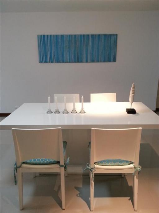 Modern dining room with white table and art piece