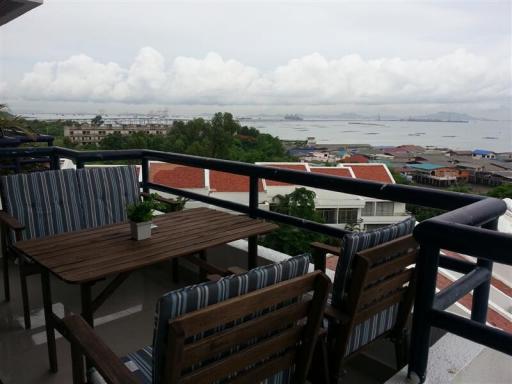 Balcony with outdoor furniture overlooking a coastal town