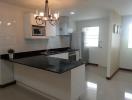 Modern kitchen with stainless steel appliances and chandelier